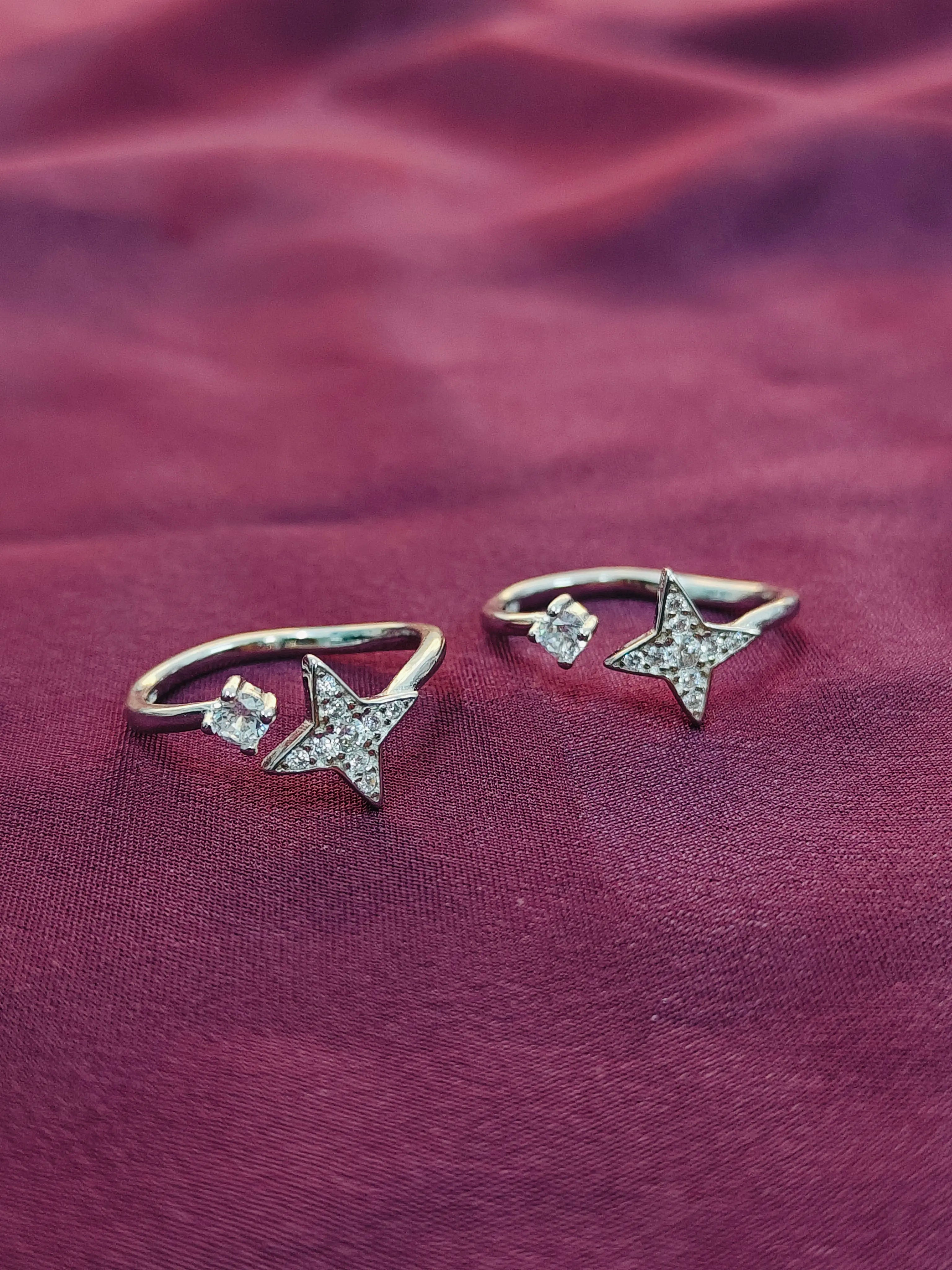 Star-shaped silver earrings on a purple fabric background